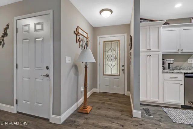 a view of a hallway with wooden floor and cabinet