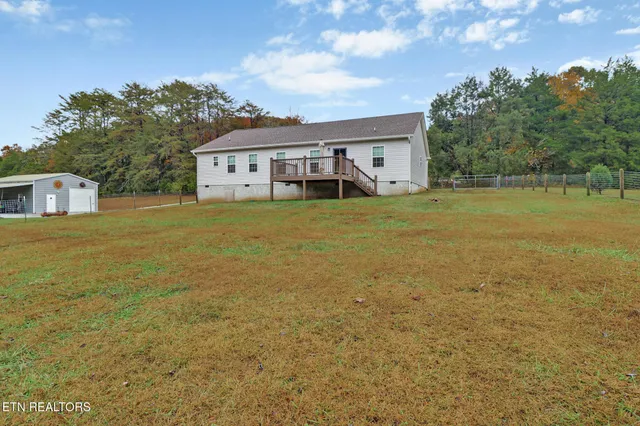 a front view of house with yard and trees in the background