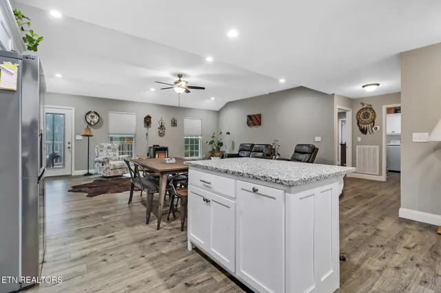 a large kitchen with kitchen island a sink table and chairs