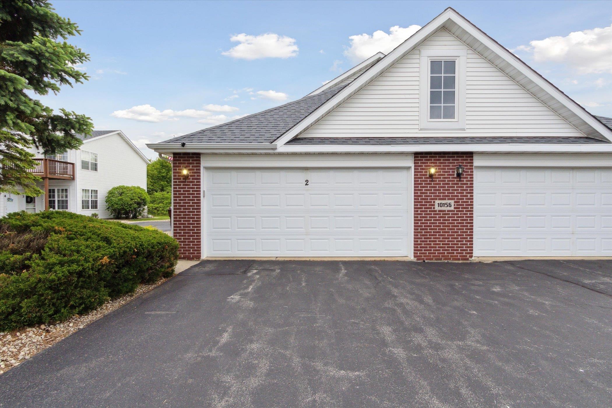 10156 Metalmark Lane, Unit 2 Roscoe, IL 61073 - Photo 1 of 38 a front view of a house with yard and garage