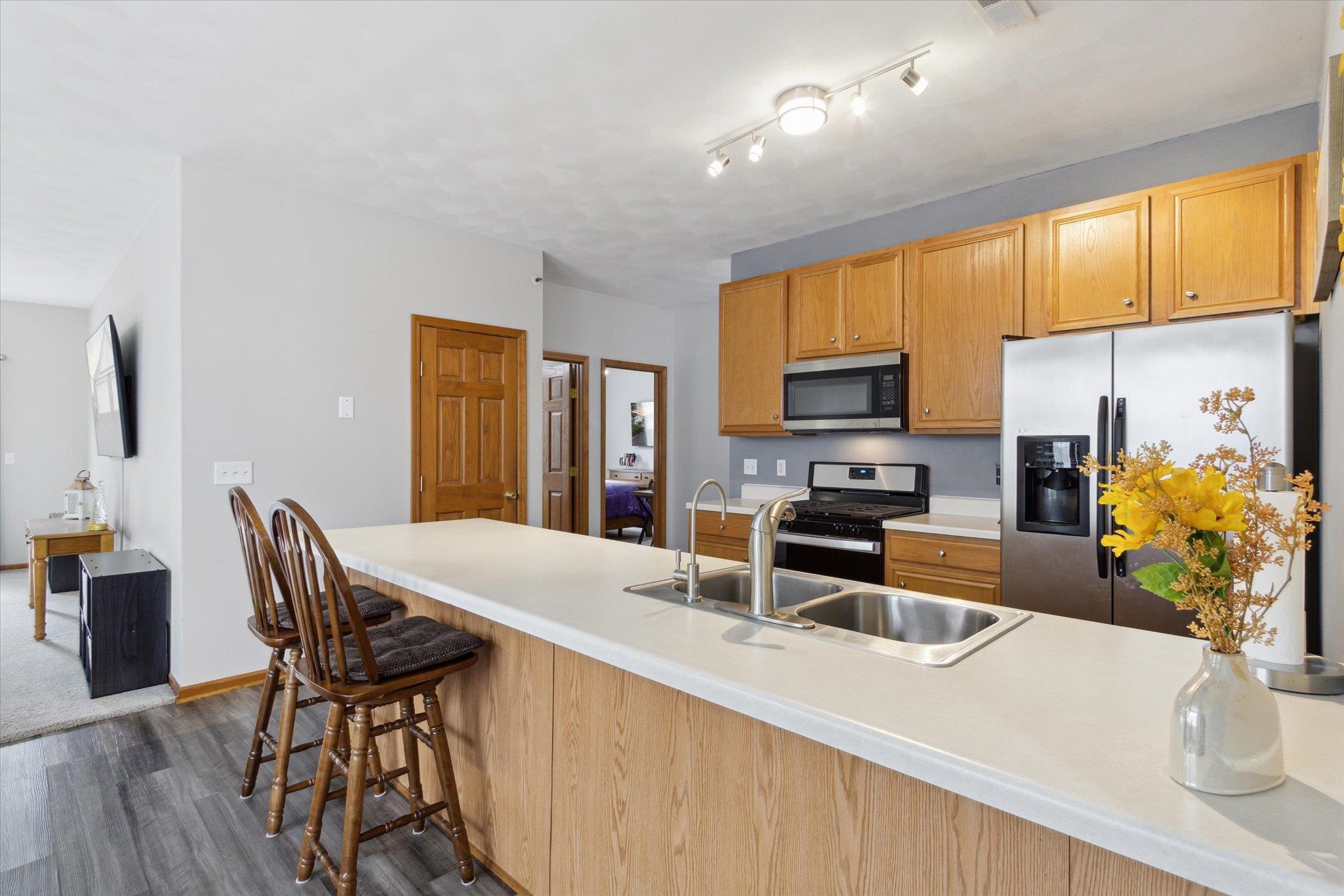 10156 Metalmark Lane, Unit 2 Roscoe, IL 61073 - Photo 16 of 38 a kitchen with stainless steel appliances microwave stove refrigerator and wooden floor