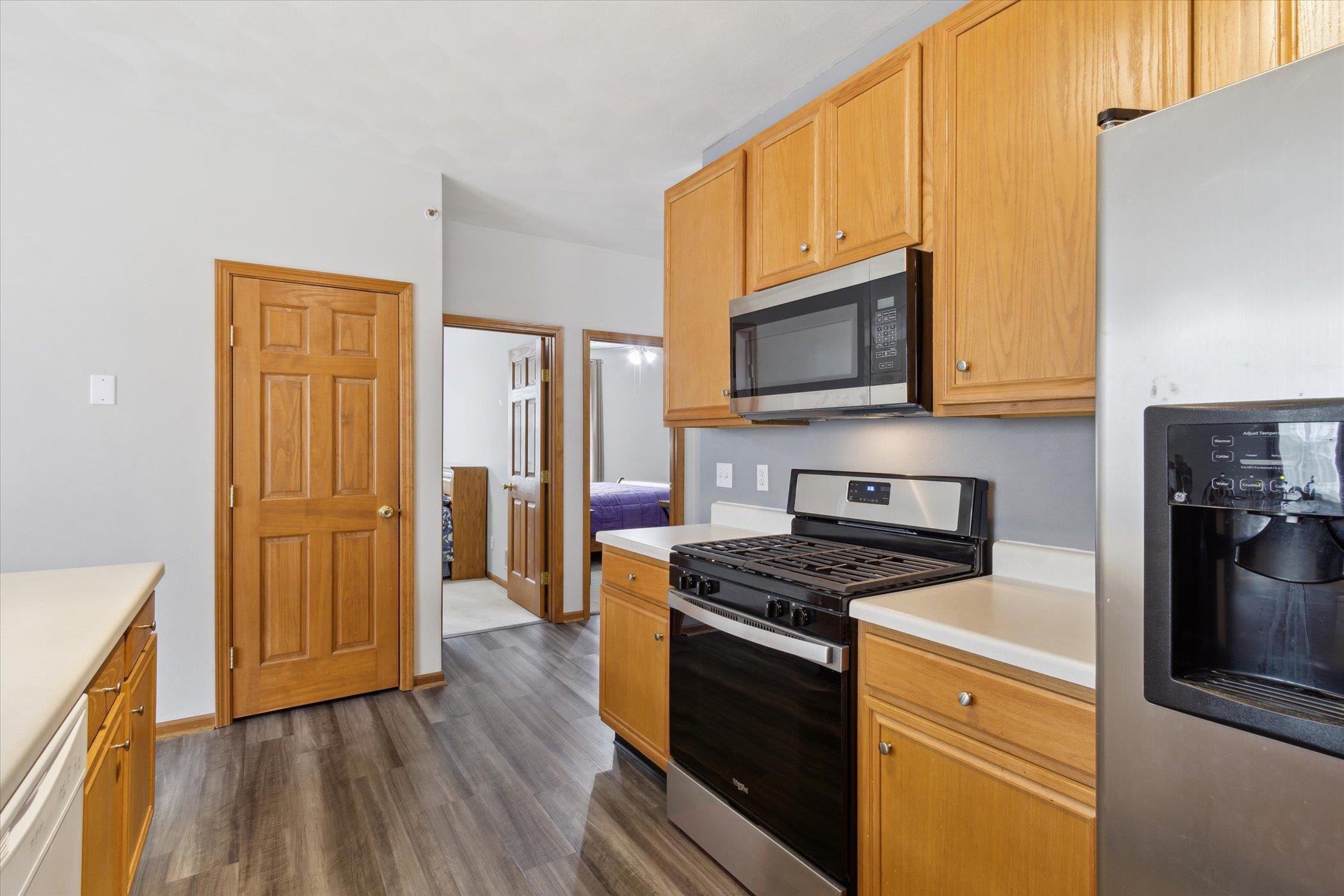 10156 Metalmark Lane, Unit 2 Roscoe, IL 61073 - Photo 19 of 38 a kitchen with granite countertop wooden cabinets stainless steel appliances and a counter space