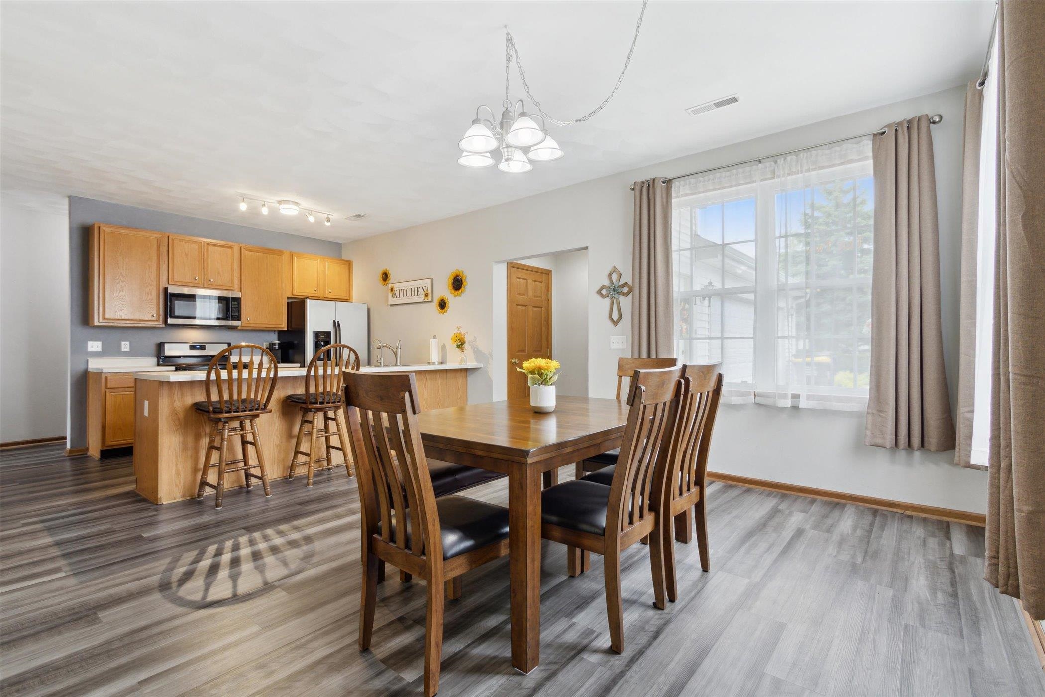 10156 Metalmark Lane, Unit 2 Roscoe, IL 61073 - Photo 8 of 38 a view of a dining room with furniture and wooden floor