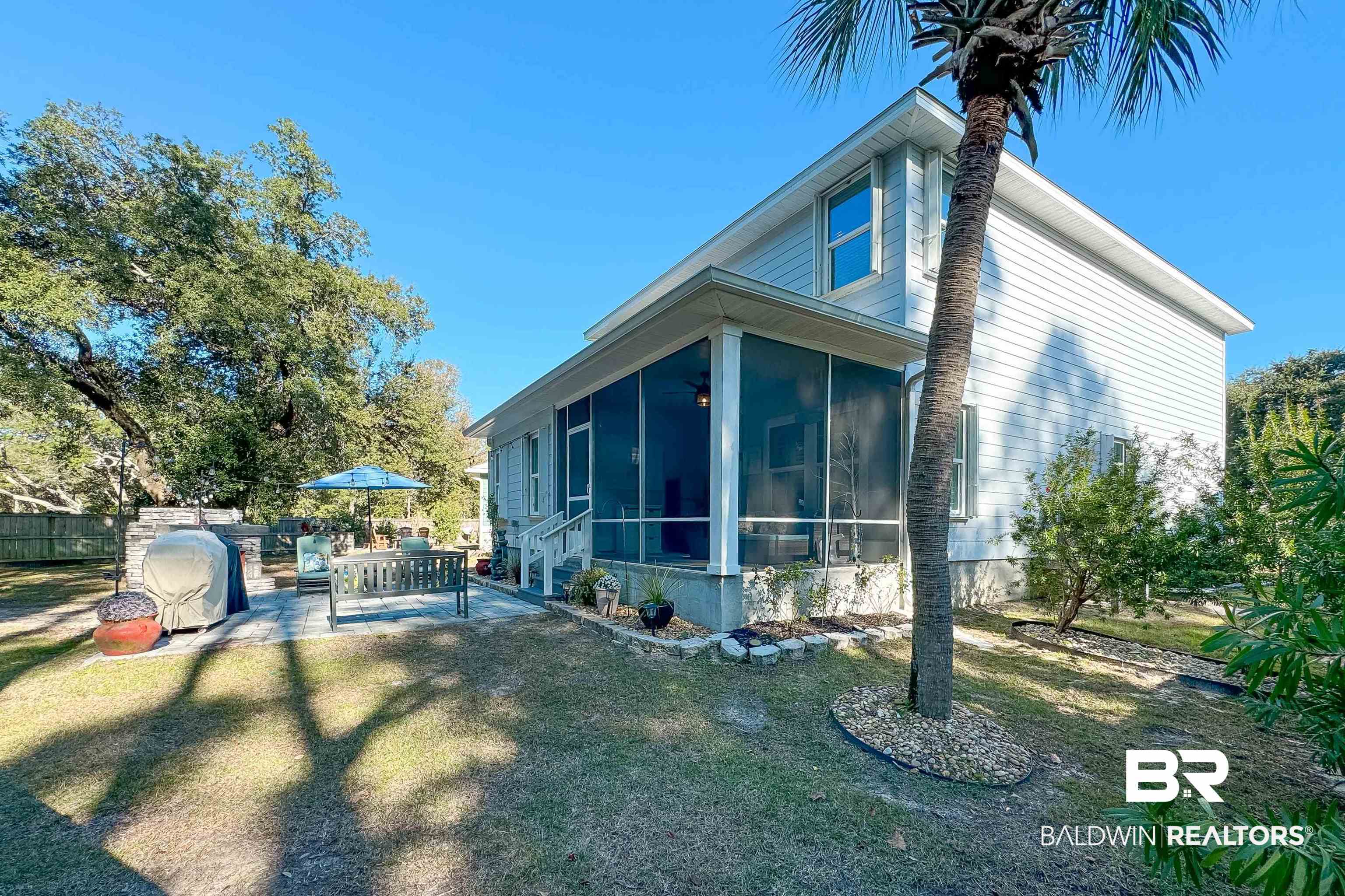 1290 Mako Loop Gulf Shores, AL 36542 - Photo 41 of 50 View of side of home featuring a sunroom, a patio area, fence, and a lawn