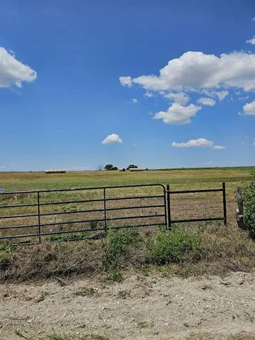 a view of a yard with wooden fence
