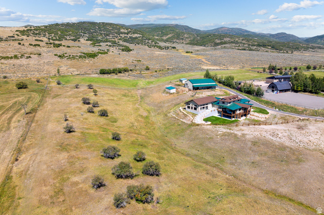 6117 North Rocky Ridge Road Peoa, UT 84061 - Photo 80 of 82 Expansive property featuring a multi-level residence with multiple balconies, a large barn, an additional structure, and a fenced riding arena