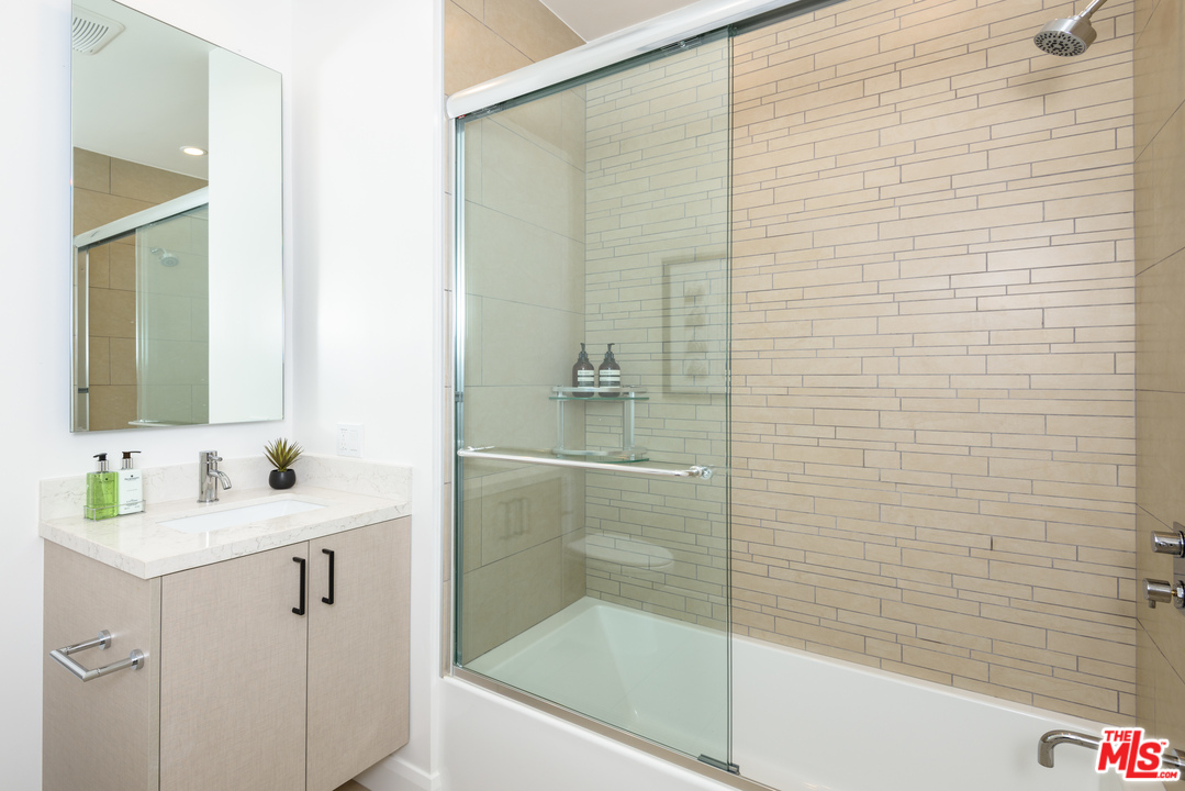 956 5th Street, Unit C Santa Monica, CA 90403 - Photo 5 of 13 a bathroom with a shower sink and mirror