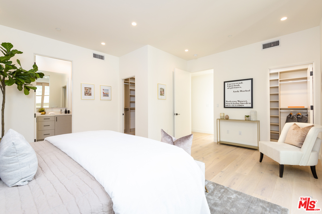 956 5th Street, Unit C Santa Monica, CA 90403 - Photo 8 of 13 a spacious bedroom with a bed a couch and a potted plant