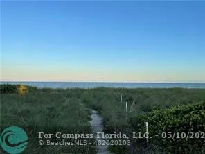a view of a hallway with wooden floor and a cabinet