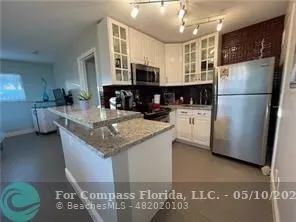 a kitchen with stainless steel appliances granite countertop a sink refrigerator and microwave