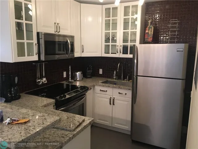 a kitchen with stainless steel appliances granite countertop a stove a refrigerator and a microwave