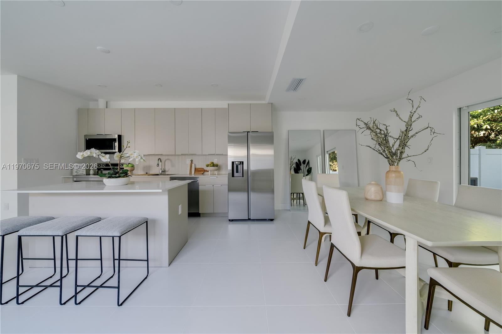 4789 Northwest 1st Street Miami, FL 33126 - Photo 15 of 28 a kitchen with stainless steel appliances a table chairs refrigerator and cabinets