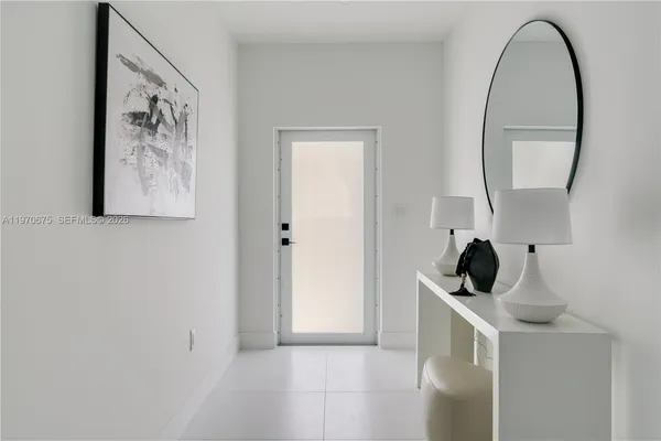 a view of a hallway to rooms and a mirror