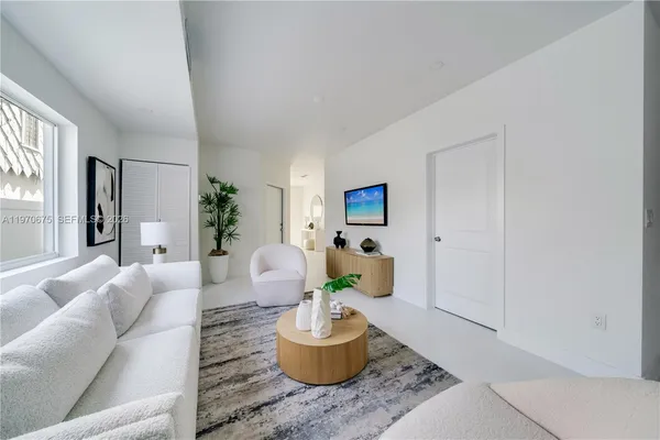a living room with patio furniture and a potted plant