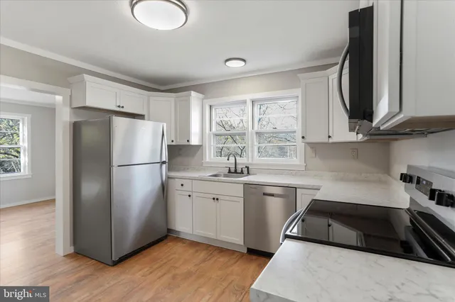 a kitchen with a refrigerator sink and cabinets