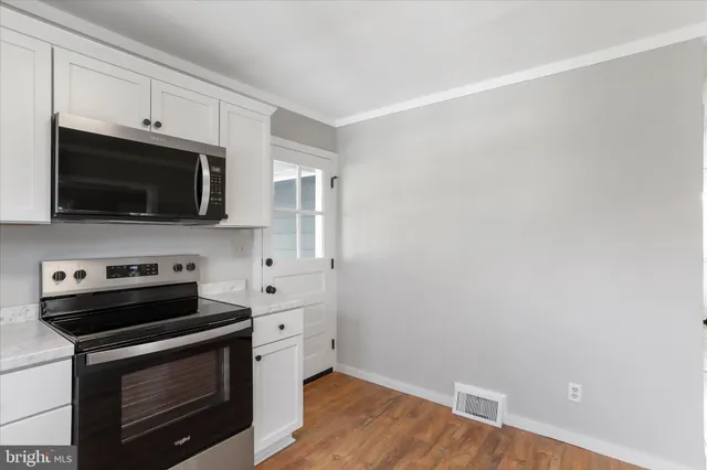 a kitchen with stainless steel appliances a stove microwave and cabinets