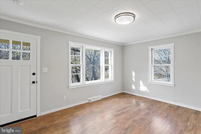 wooden floor in an empty room with a window
