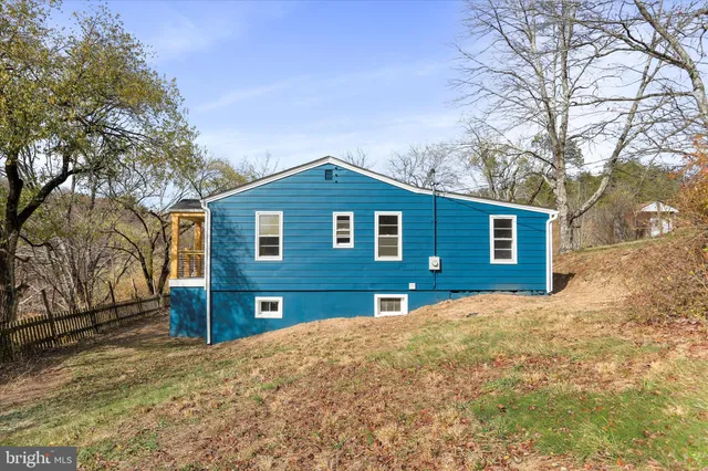 a front view of a house with yard and large trees