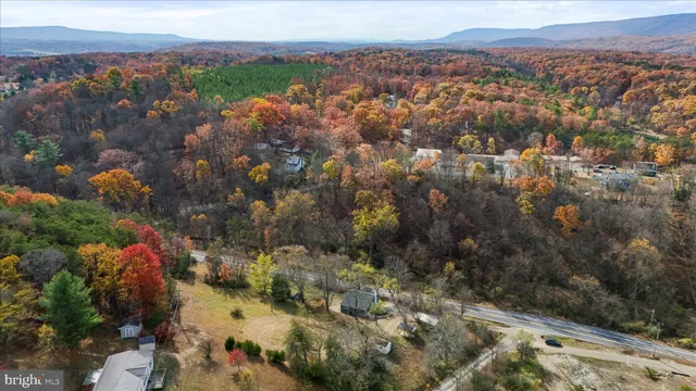 an aerial view of house with yard and mountain view in back