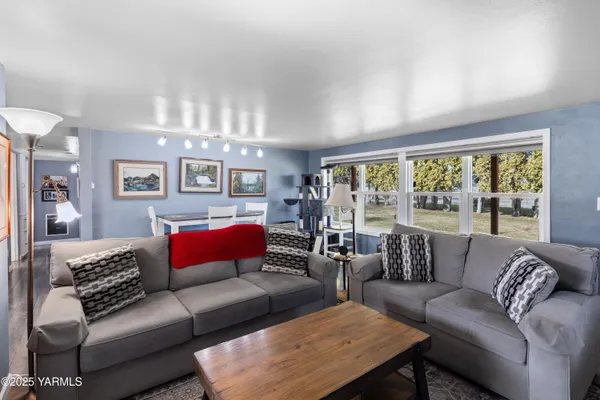 a kitchen with a refrigerator a sink dishwasher a stove and a dining table with wooden floor