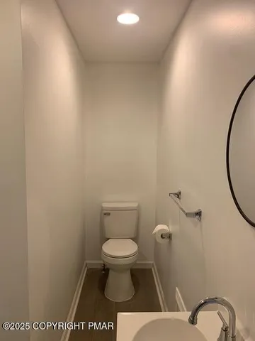 a bathroom with a toilet and a mirror