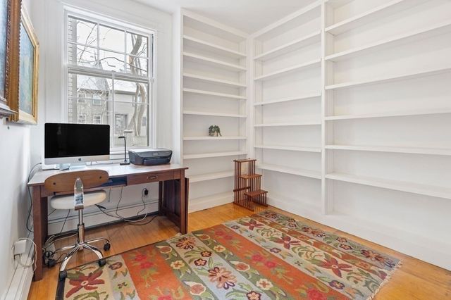 a view of a workspace with furniture and a window