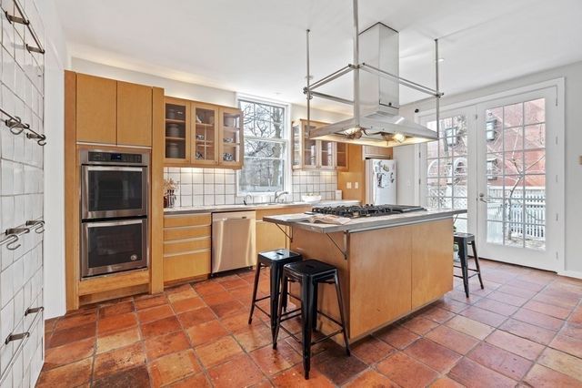 a kitchen with granite countertop a stove a sink and a refrigerator