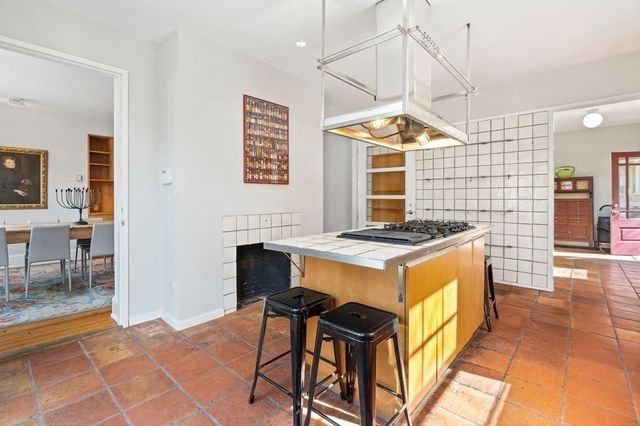 a kitchen with stainless steel appliances kitchen island a stove a sink and a refrigerator