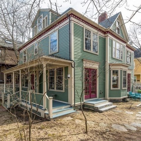 a view of a house with wooden fence and a tree