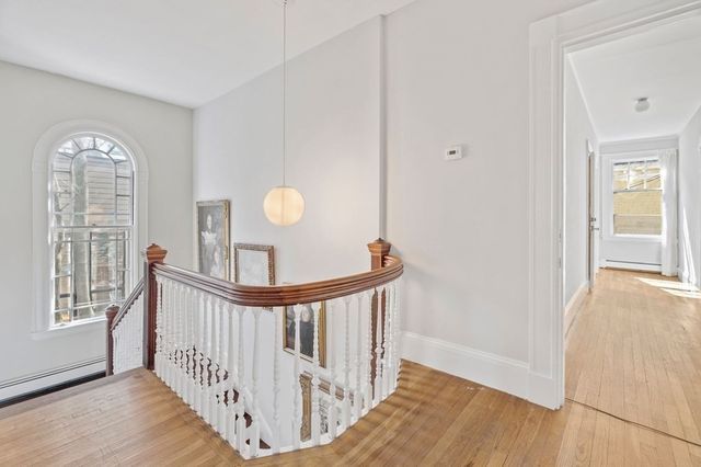 a view of a hallway view with wooden floor and windows