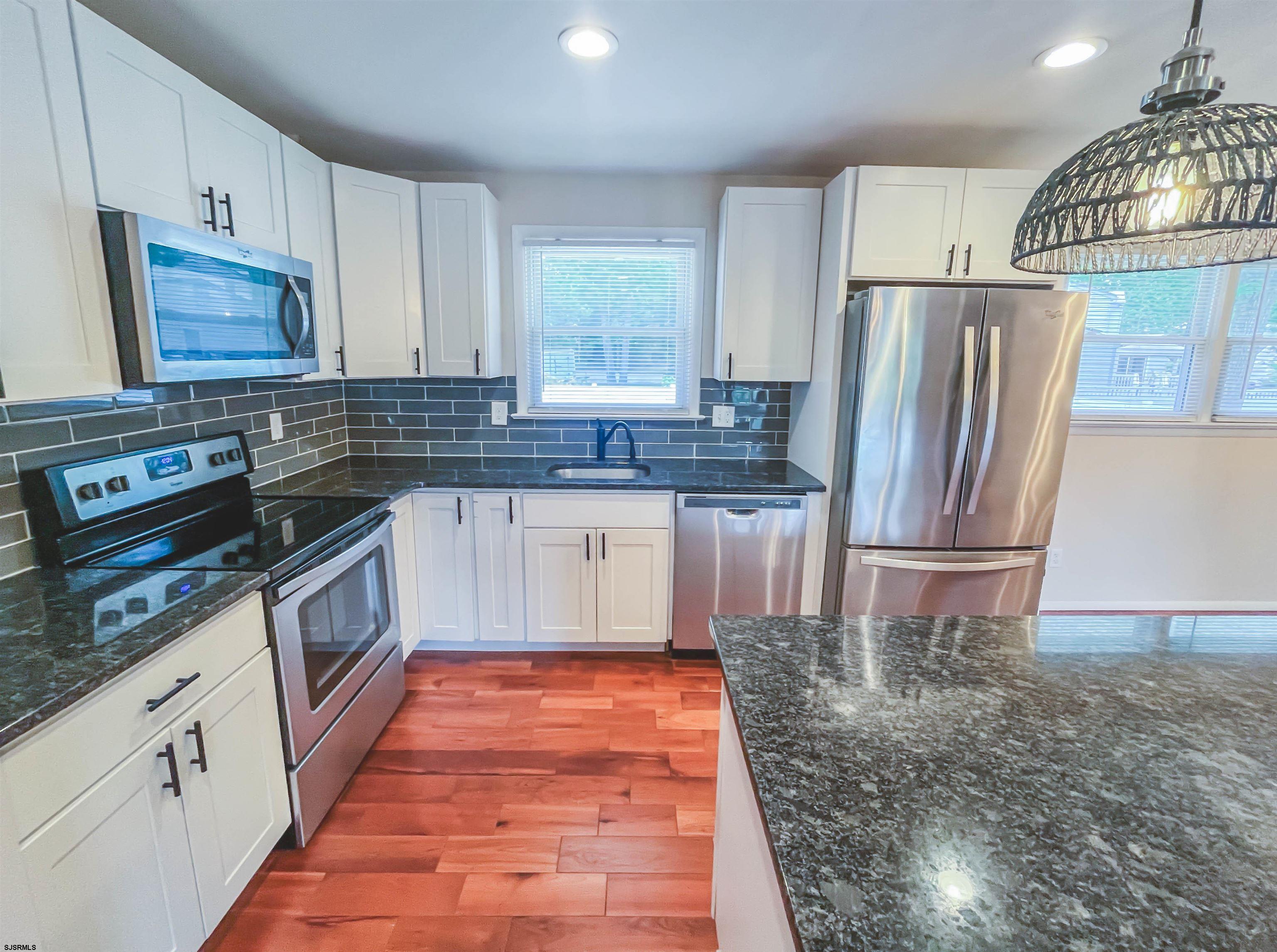 518 Delaware Avenue Absecon, NJ 08201 - Photo 11 of 38 a kitchen with stainless steel appliances granite countertop a refrigerator stove and sink