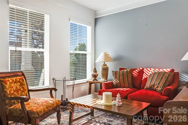 a bed sitting in a bedroom next to a window and a chair