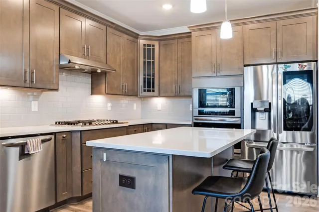 a kitchen with stainless steel appliances a stove a refrigerator and a sink