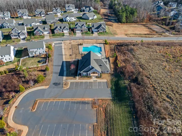 an aerial view of a house with a yard and wooden fence