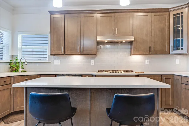 a kitchen with granite countertop a stove a sink and a table