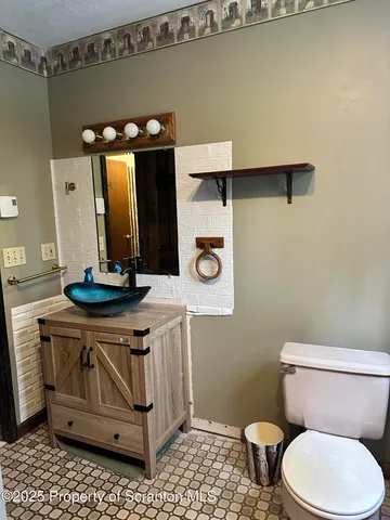 a bathroom with a toilet a sink and mirror