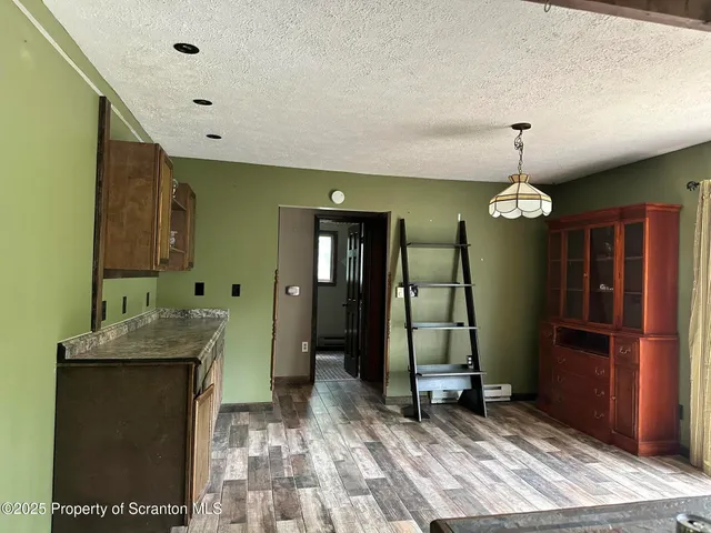 a view of a hallway of a livingroom with furniture wooden floor and window