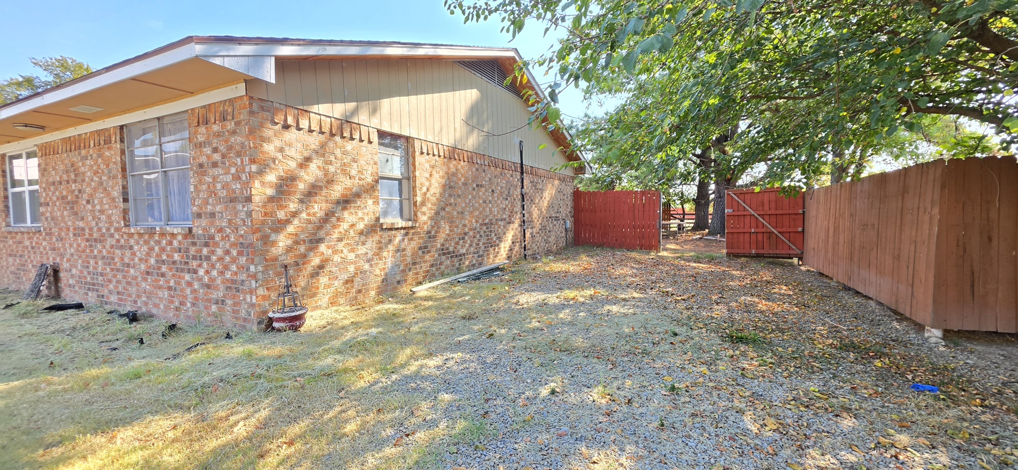 107903 South 4570 Road Sallisaw, OK 74955 - Photo 2 of 35 Brick exterior with multiple windows, wood siding, and a fenced perimeter