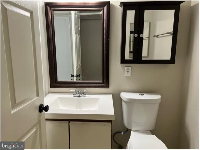 a bathroom with a toilet sink and mirror