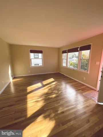 a view of empty room with window and wooden floor