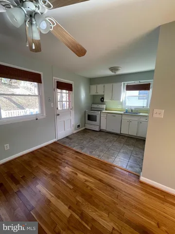 a large kitchen with kitchen island a stove a sink dishwasher and a fireplace with wooden floor
