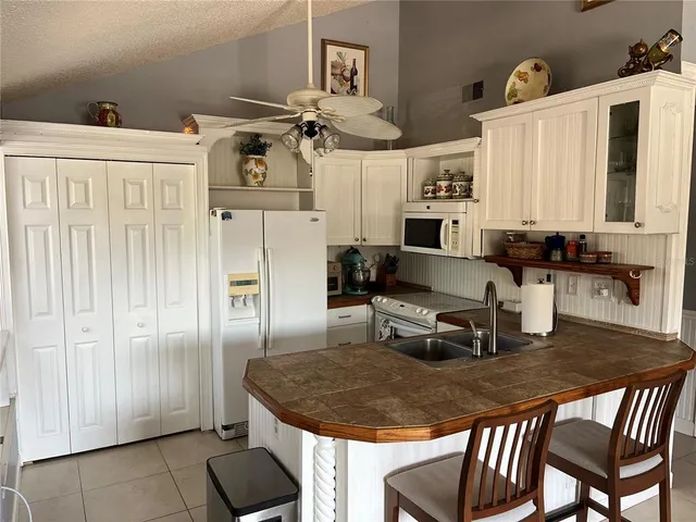 a kitchen with stainless steel appliances granite countertop a sink dishwasher and a refrigerator with wooden floor