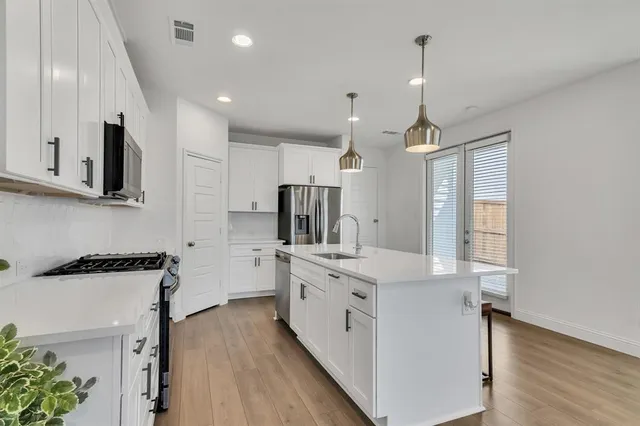 a kitchen with stainless steel appliances kitchen island granite countertop a sink stove and refrigerator