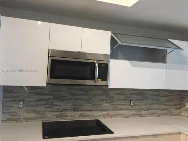 a kitchen with granite countertop a stove and a microwave