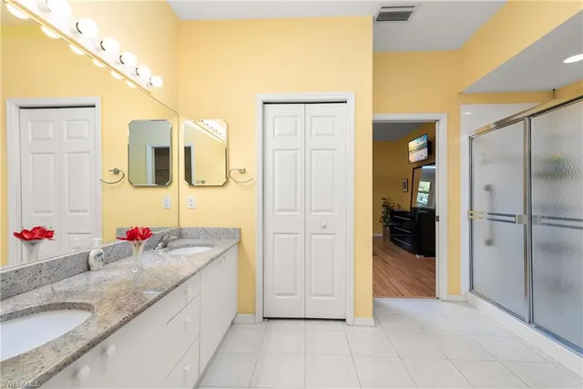 a spacious bathroom with a granite countertop sink mirror and shower