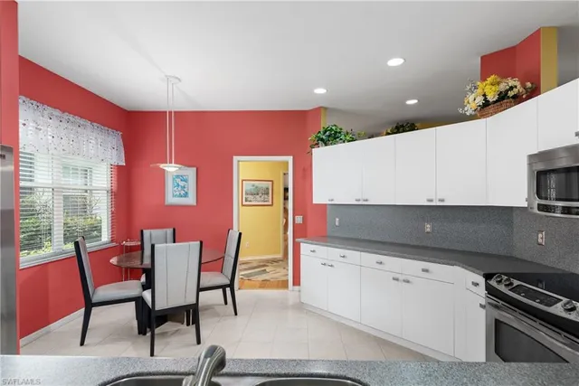 a kitchen with granite countertop a stove a sink and a refrigerator