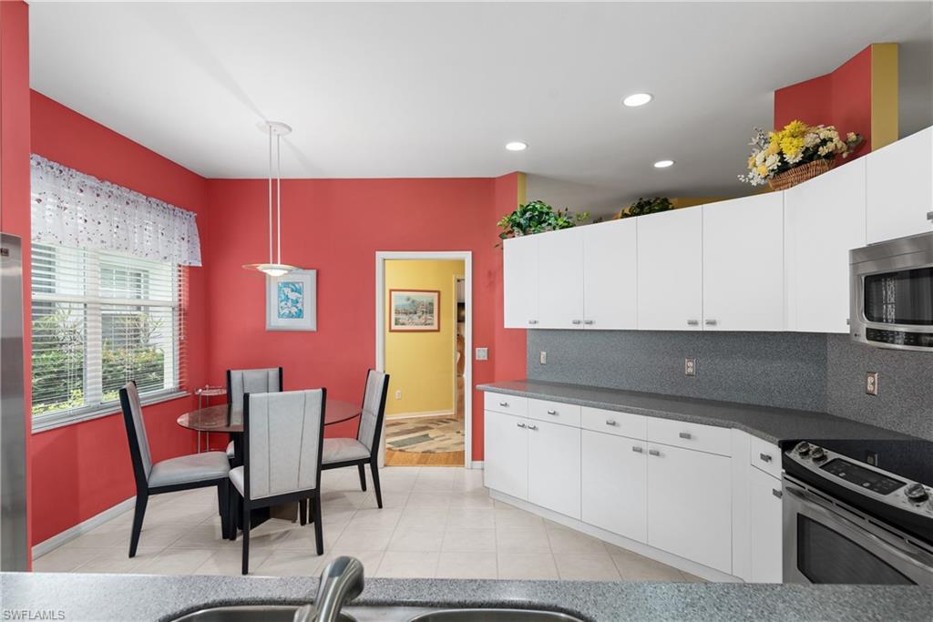 455 Crossfield Circle, Unit 71 Naples, FL 34104 - Photo 7 of 29 a kitchen with granite countertop a stove a sink and a refrigerator