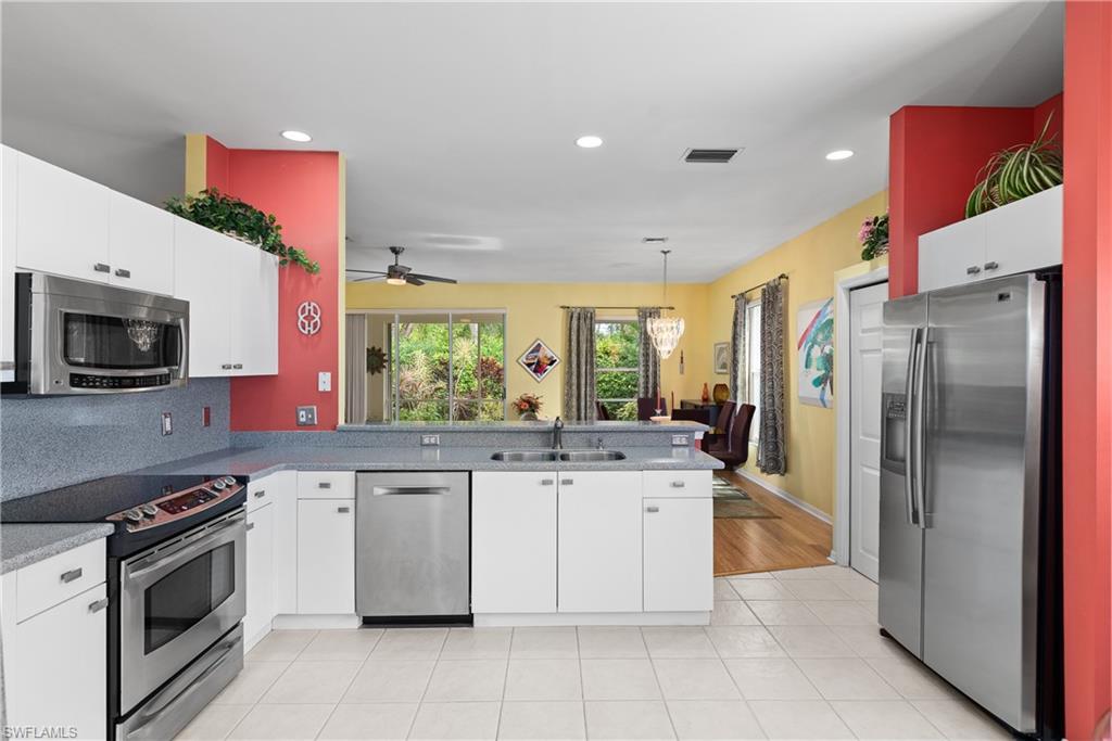 455 Crossfield Circle, Unit 71 Naples, FL 34104 - Photo 9 of 29 a kitchen with stainless steel appliances granite countertop a stove top oven a sink and a refrigerator