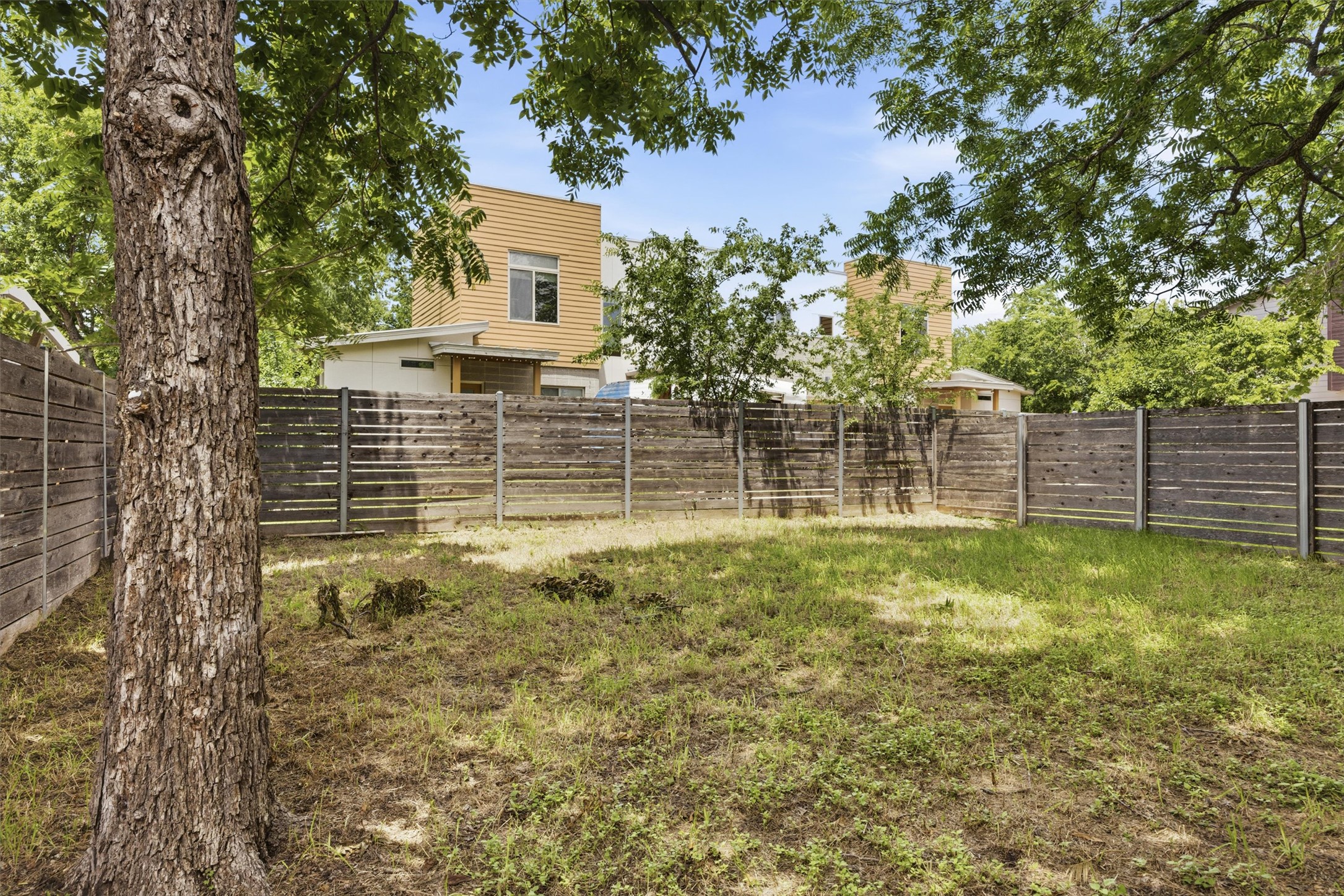 1210 Stobaugh Street, Unit B Austin, TX 78757 - Photo 3 of 40 A well-maintained wooden fence encloses a spacious yard, providing privacy and a serene outdoor area.
