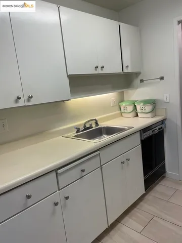 a kitchen with granite countertop white cabinets and a sink